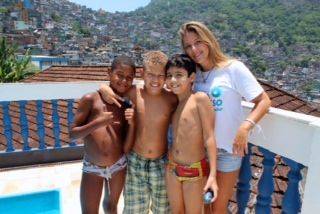 Chantal Teixeira with her students at the school, with Rocinha community in the background.